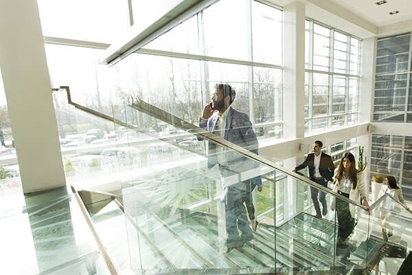office staff climbing glass staircase