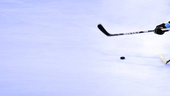 Ice hockey players competing for the puck on an ice rink.