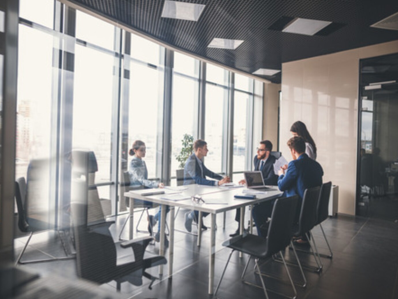 A group of office employees discussing work in a meeting room